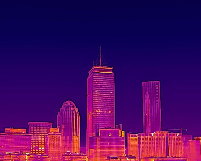 Thermal image of a city skyline, towers glowing against a deep purple sky