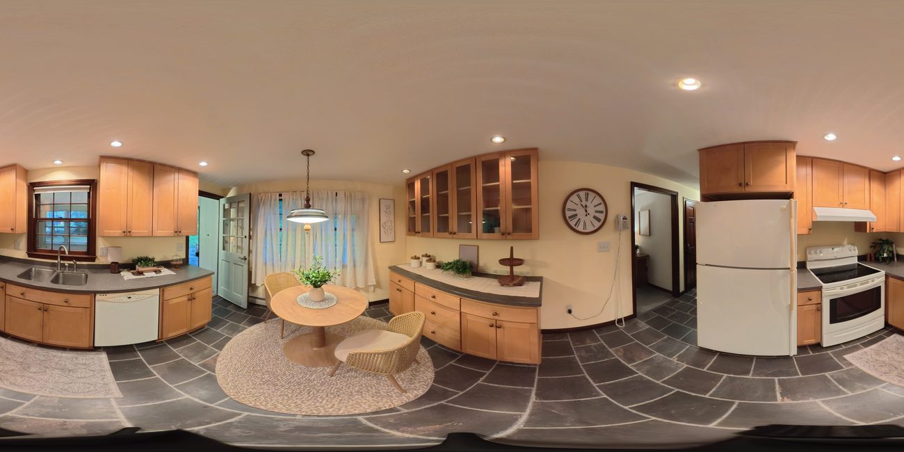 Spherical panorama of a kitchen and eating area, cabinetry and slate floor wrapping around the viewer
